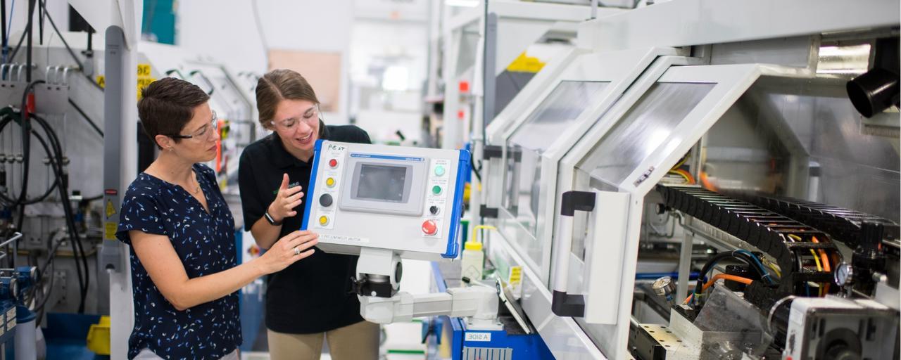 Two women working on a machine